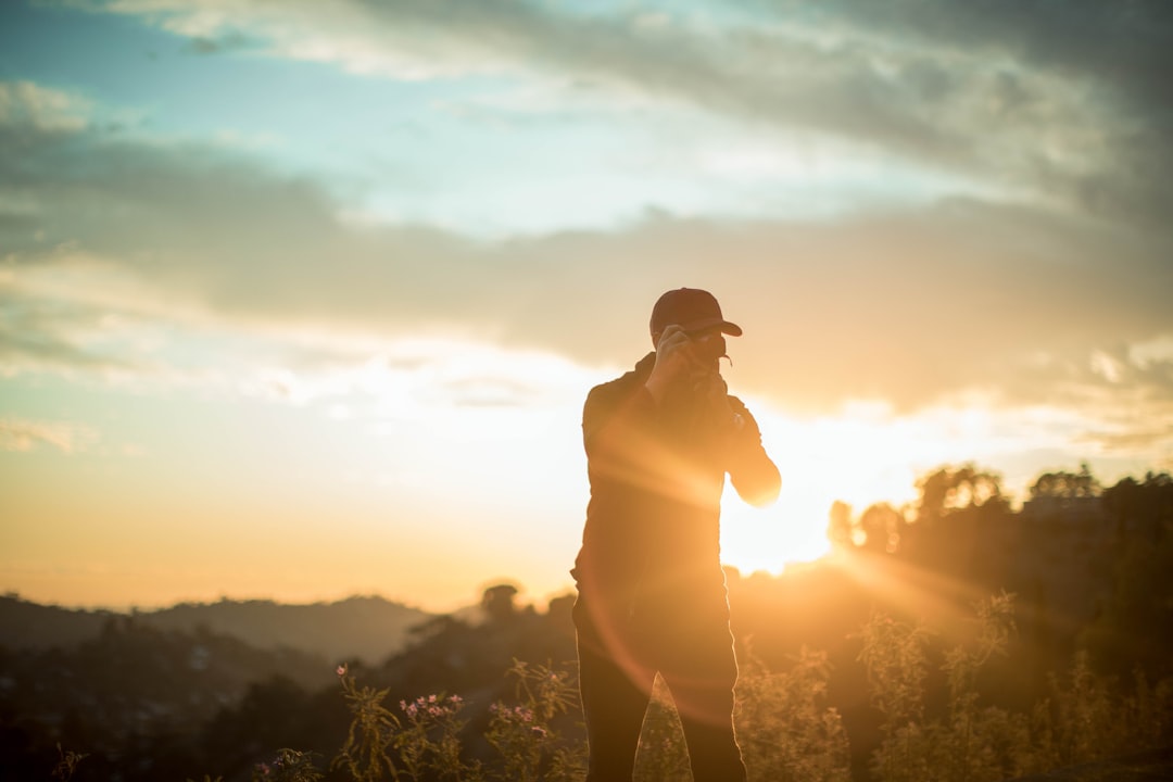 man holding DSLR camera taking photo during daytime