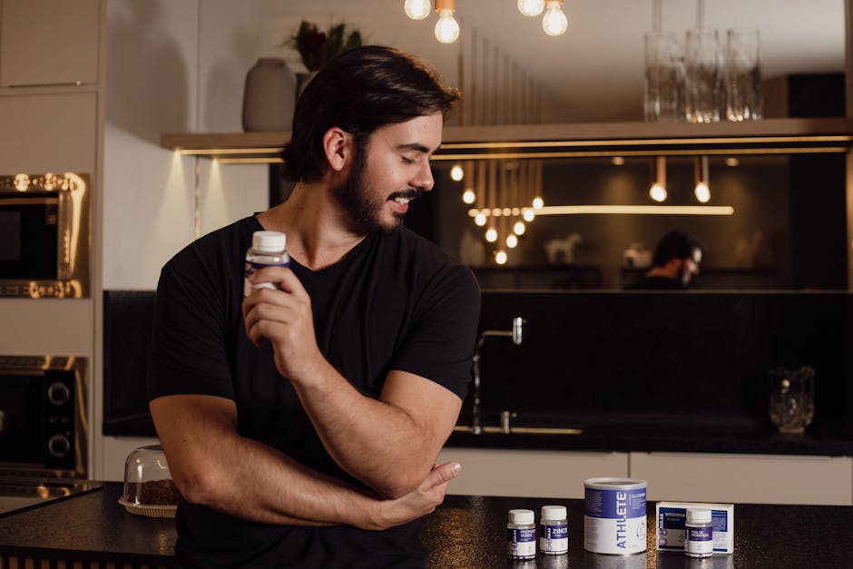 Adult man holding a supplement bottle with multiple jars on a countertop in a modern kitchen setting.