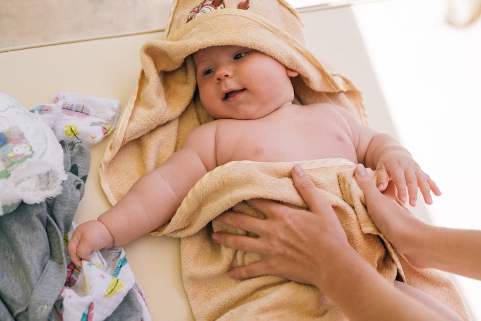 Cute newborn baby wrapped in a soft towel, smiling and feeling cozy indoors.