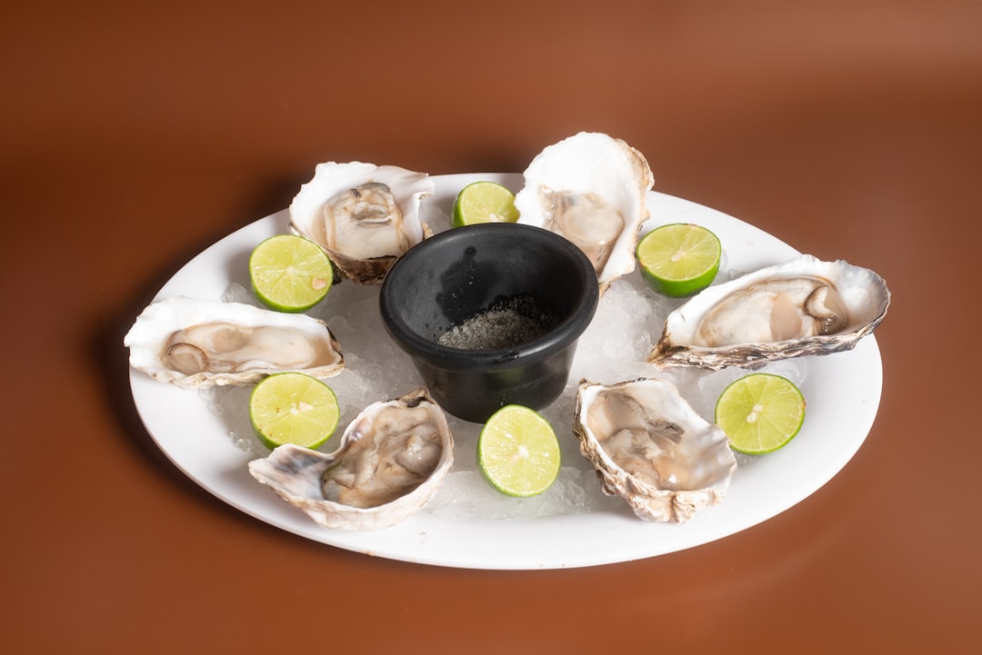 A white plate topped with oysters and limes