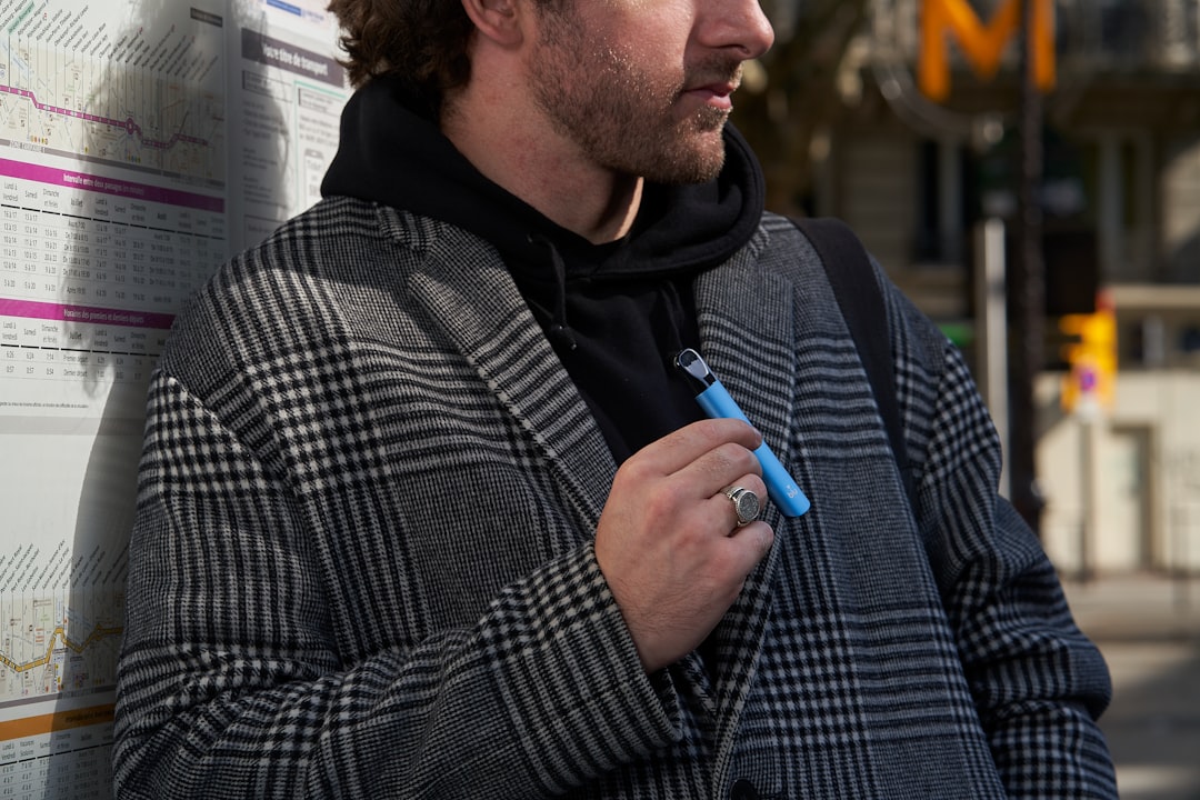 a man standing next to a wall with a pen in his hand