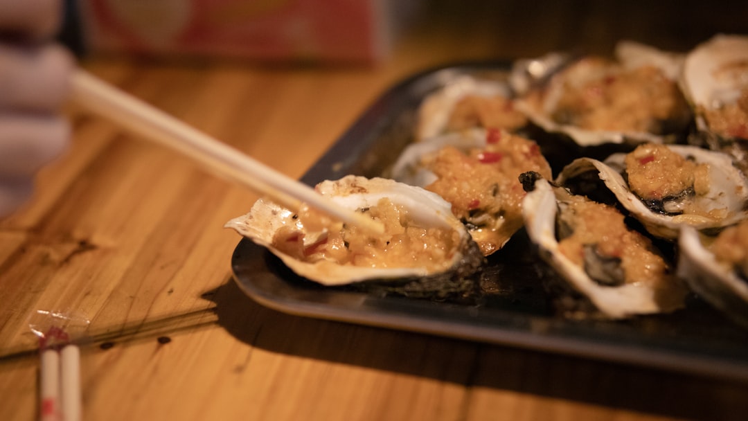 a plate of oysters on a table with chopsticks