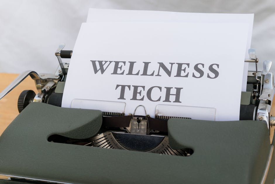 A close-up of a vintage typewriter featuring a paper with the words 'Wellness Tech.'