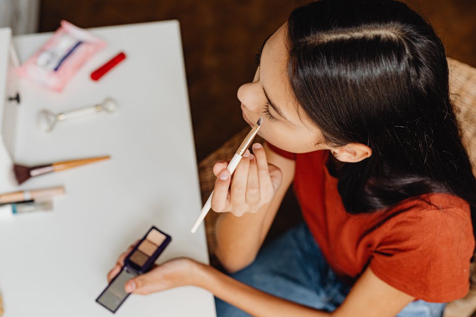 Teenage girl applying eyeshadow at home as part of her beauty routine.