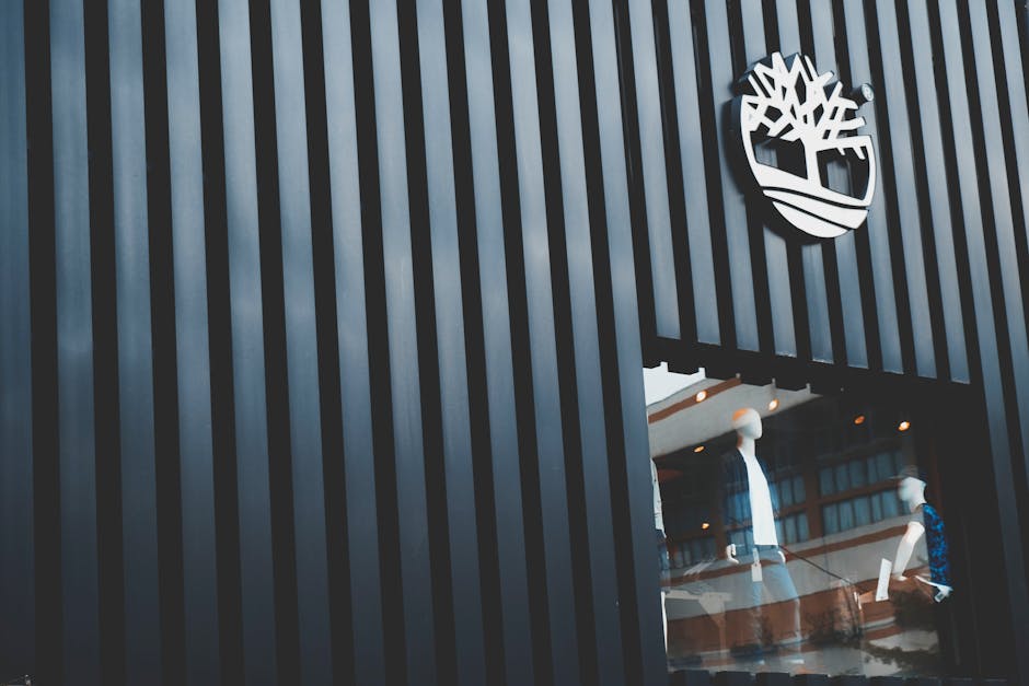 Modern storefront with displayed mannequins showcasing fashion in Taipei's urban setting.