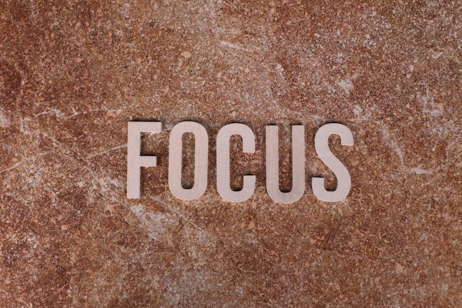 Wooden letters spelling 'FOCUS' on a textured brown surface for emphasis.