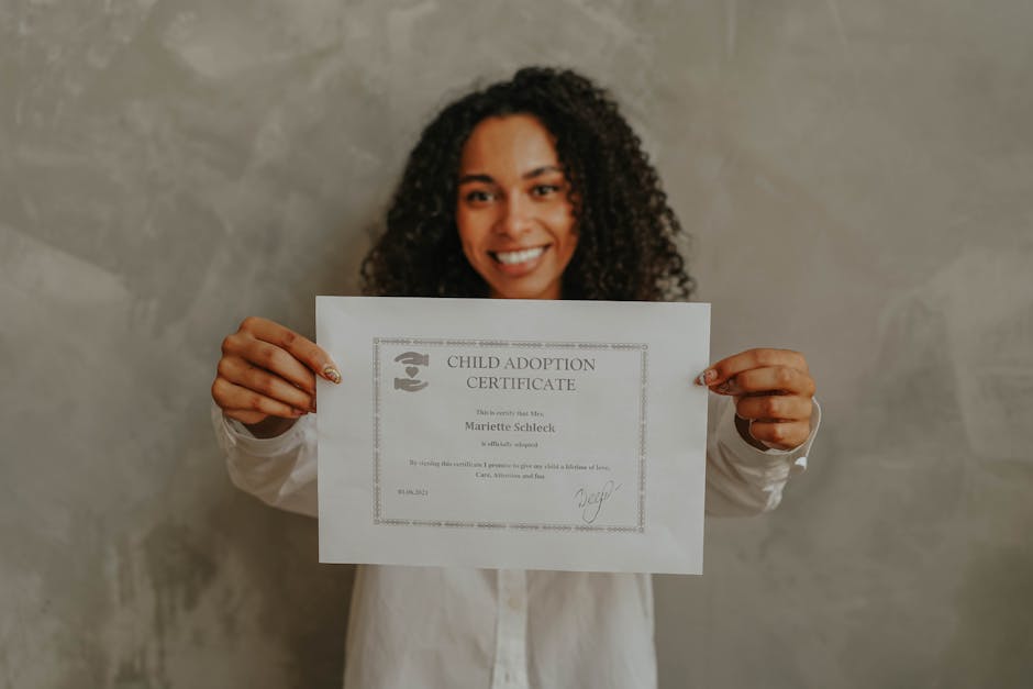 A smiling woman proudly holds a child adoption certificate indoors.