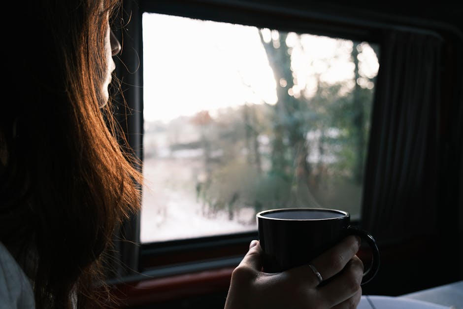 A serene moment captured as a woman savors her coffee by the window, soaking in the morning light.