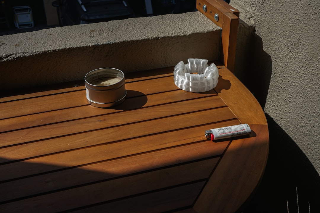 Ashtray, lighter, and tobacco sit on wood.